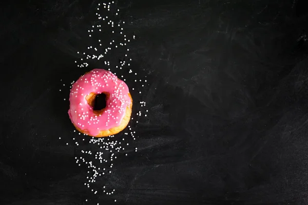 Donut rosa no fundo preto — Fotografia de Stock