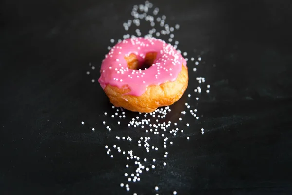 Donut rosa no fundo preto — Fotografia de Stock