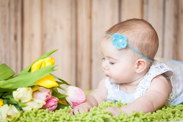 Adorable petite fille avec des tulipes — Photo