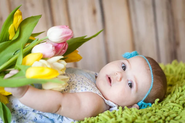Adorable petite fille avec des tulipes — Photo