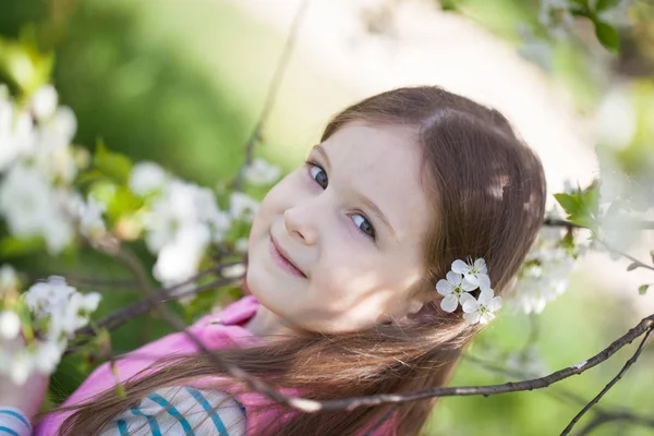 Nettes Mädchen in einem blühenden Kirschbaumgarten — Stockfoto