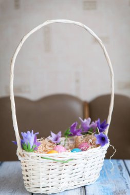 Tahta bir masada sepetteki paskalya yumurtaları.