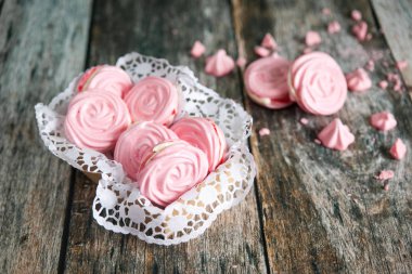 Ahşap arka plan üzerinde pembe ahududu meringues