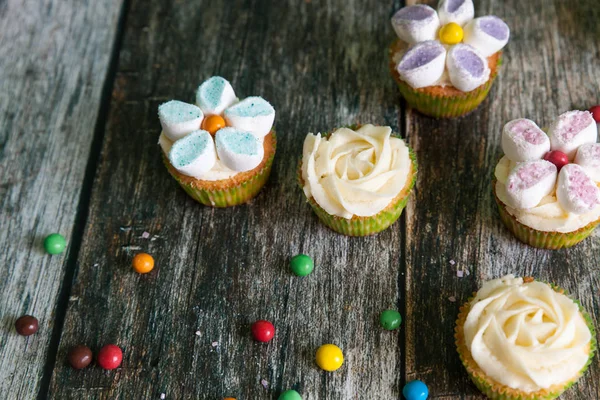 Pasteles decorados con crema de mantequilla y flores de malvavisco — Foto de Stock