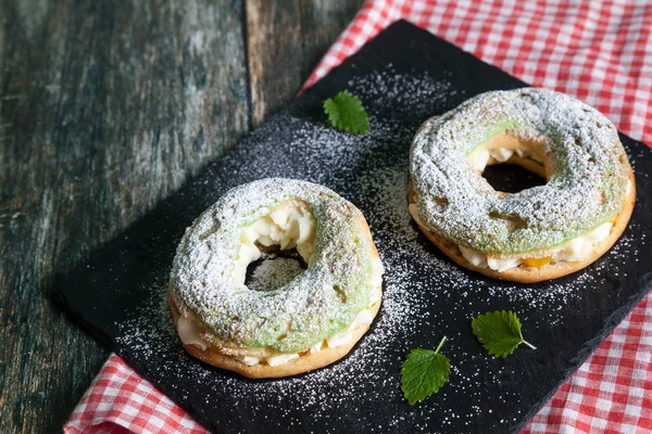 Anéis de Eclair com um creme e pêssegos enlatados — Fotografia de Stock