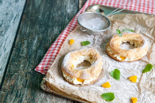 Anéis de Eclair com um creme e pêssegos enlatados — Fotografia de Stock