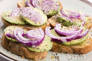 Taze avokado ve soğanlı sandviç.