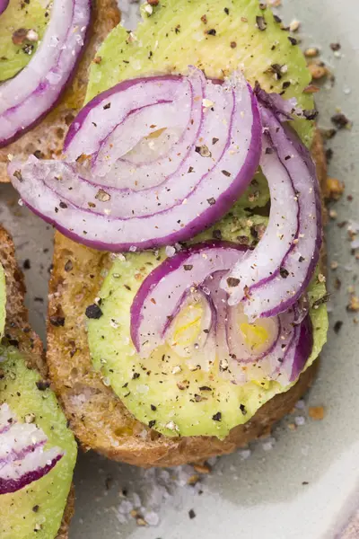 Sandwich mit frischer Avocado und Zwiebeln auf einem Teller — Stockfoto