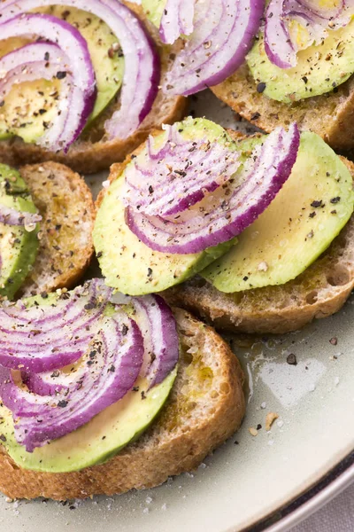 Sandwich mit frischer Avocado und Zwiebeln auf einem Teller — Stockfoto