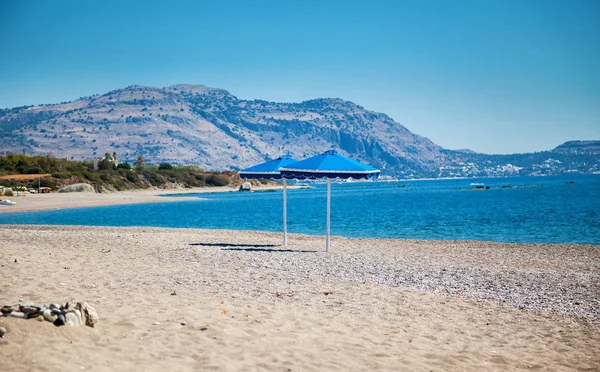 ロードス ギリシャのビーチでの つの青い傘 — ストック写真