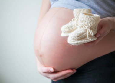 Yeni doğan karın arka plan hamile bir kadını elinde için güzel örgü patik