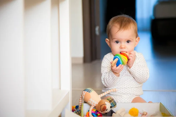 Niedliche Baby Mädchen Nagt Ein Hölzernes Buntes Spielzeug — Stockfoto