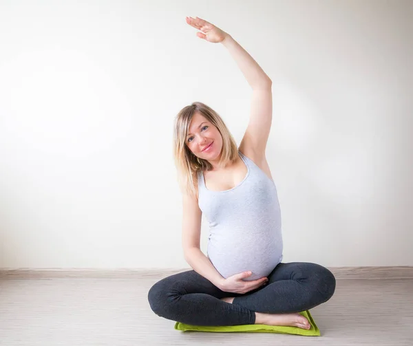 Uśmiecha Się Kobieta Ciąży Rozciąganie Jej Ramię Pozycji Lotosu — Zdjęcie stockowe