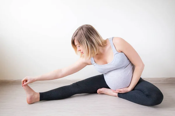 Gravid Kvinna Stretching Hennes Arm Och Ben Hålla Hennes Mage — Stockfoto