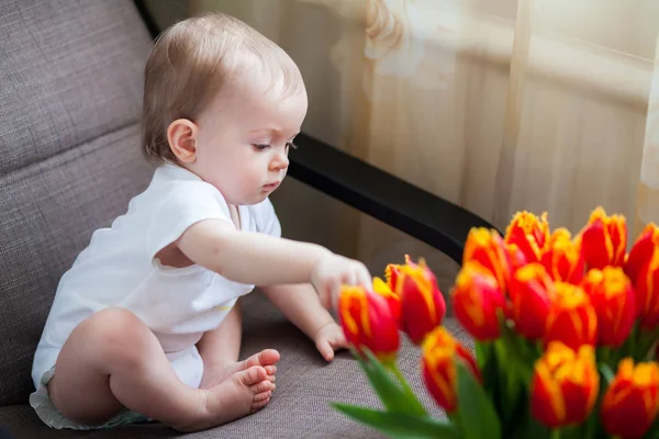 Pequena Menina Tocando Tulipas Vermelhas — Fotografia de Stock