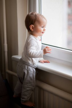 küçük bebek kız pencerenin ayakta