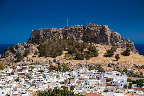 view with the small white residential houses in Lindos and ancient Acropolis above, Rhodes island, Greece