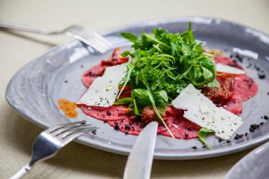yakın çekim carpaccio et roka ve parmesan peyniri dilimleri ile