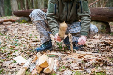 adam için kamp ateşi yakacak odun sopa bıçak ile kesme