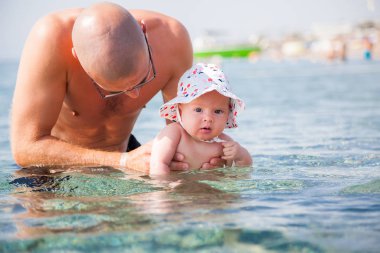 onun sevimli küçük bebek kız Denizde yüzme öğretme baba