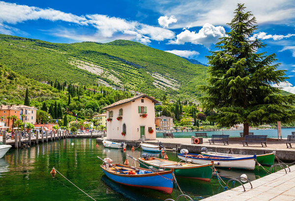 Beautiful landscape with boats in the fishing harbor in Nago-Torbole, Garda lake, Trentino region, Italy