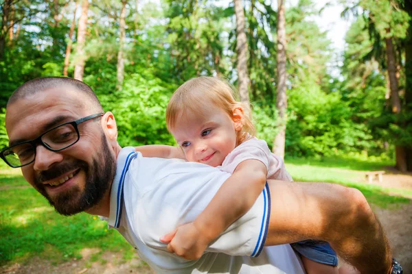 Man carrying daughter on his back — Stock Photo, Image