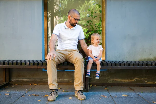 Far och hans dotter sitter på en bänk — Stockfoto