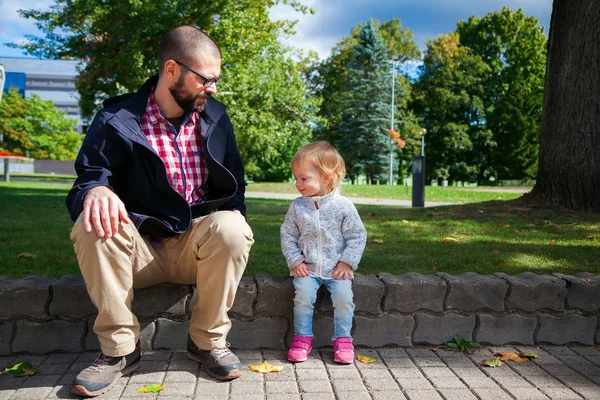 Menina e seu pai sentado em uma calçada — Fotografia de Stock