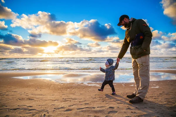 Father and daughter walking along the shore — Stock Photo, Image