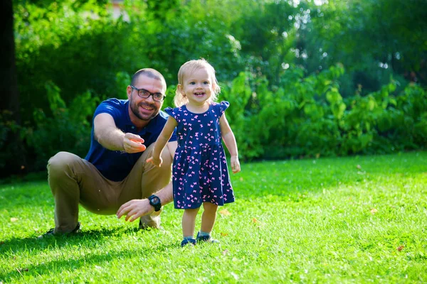 Liten flicka och hennes far i den gröna parken — Stockfoto