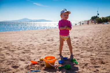 Kumsalda oynayan kız.