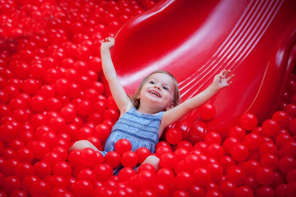 Сміється маленька дівчинка катається на слайді — стокове фото