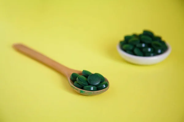 Großaufnahme Löffel Mit Grünen Spirulina Pillen Auf Gelbem Hintergrund Superfood — Stockfoto