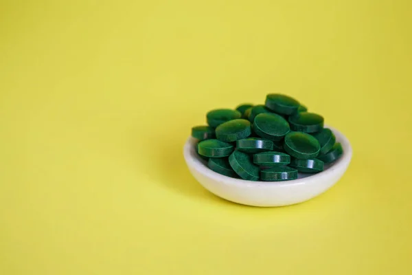 Primer Plano Pila Píldoras Espirulina Verde Sobre Fondo Amarillo Super —  Fotos de Stock