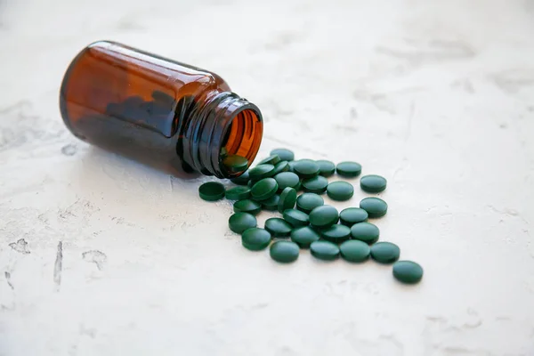 Green Spirulina Pills Dropped Out Bottle White Concrete Background Super — Stock Photo, Image