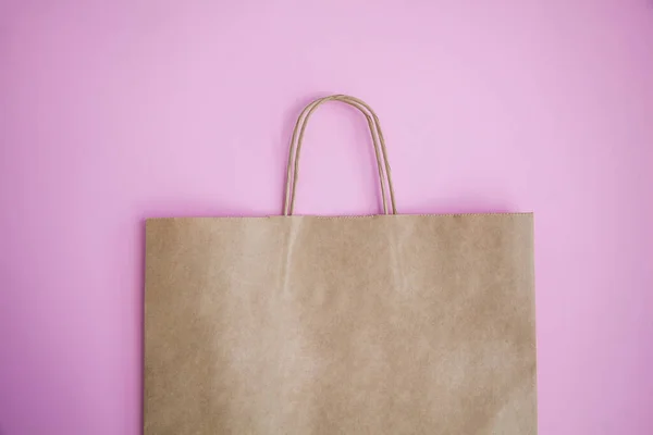 Brown paper eco friendly bag on pink background. Eco friendly, reuse and zero waste concept.