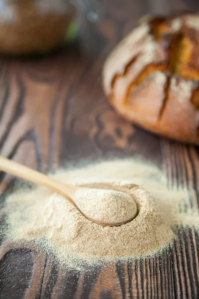 Spoon with buckwheat flour on a wooden background. Alternative flour. Gluten free and healthy eating.