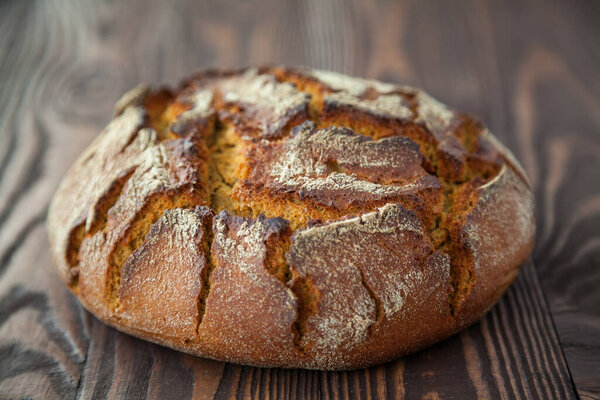 close-up crispy fresh hot rye circle bread on a wooden background