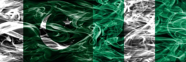 Pakistan vs Nigeria smoke flags placed side by side. Thick colored silky smoke flags of Pakistan and Nigeria