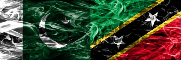 Pakistan vs Saint Kitts and Nevis smoke flags placed side by side. Thick colored silky smoke flags of Pakistan and Saint Kitts and Nevis