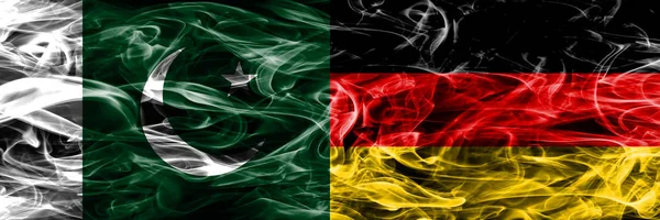 Pakistan vs Germany smoke flags placed side by side. Thick colored silky smoke flags of Pakistan and Germany
