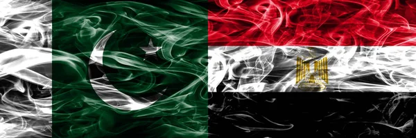 Pakistan vs Egypt smoke flags placed side by side. Thick colored silky smoke flags of Pakistan and Egypt