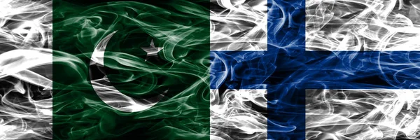 Pakistan vs Finland smoke flags placed side by side. Thick colored silky smoke flags of Pakistan and Finland