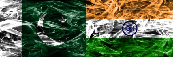 Pakistan vs India smoke flags placed side by side. Thick colored silky smoke flags of Pakistan and India