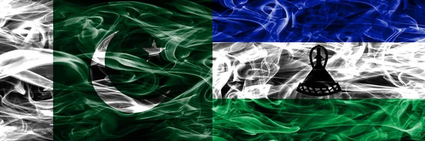 Pakistan vs Lesotho smoke flags placed side by side. Thick colored silky smoke flags of Pakistan and Lesotho