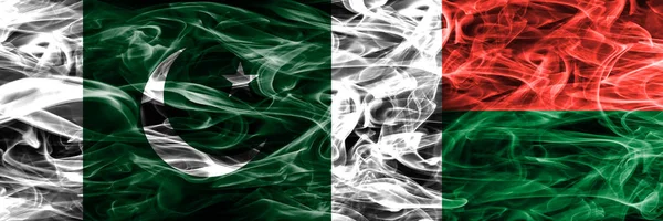 Pakistan vs Madagascar smoke flags placed side by side. Thick colored silky smoke flags of Pakistan and Madagascar