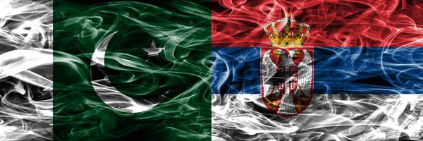 Pakistan vs Serbia smoke flags placed side by side. Thick colored silky smoke flags of Pakistan and Serbia