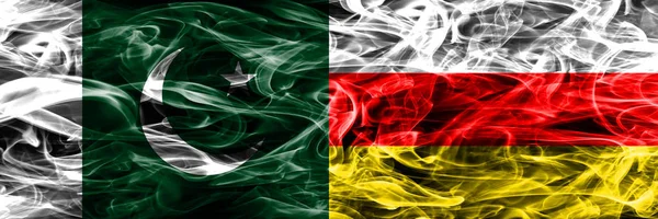 Pakistan vs South Ossetia smoke flags placed side by side. Thick colored silky smoke flags of Pakistan and South Ossetia