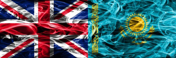 United Kingdom vs Kazakhstan smoke flags placed side by side. Thick colored silky smoke flags of Great Britain and Kazakhstan