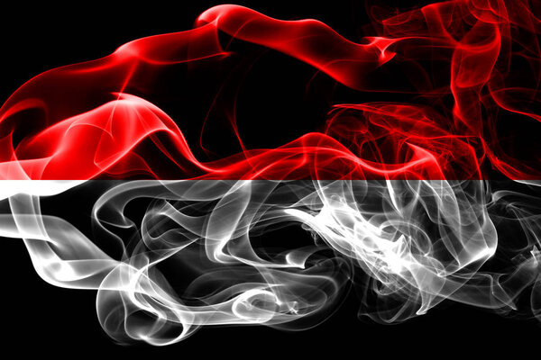 National flag of Indonesia made from colored smoke isolated on black background. Abstract silky wave background.